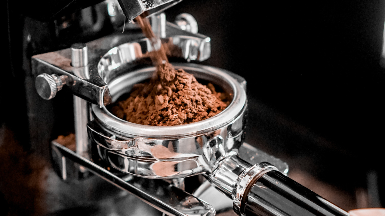 closeup coffee grinder grinding into a portafilter