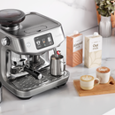 Breville THE ORACLE JET next to lattes and milk