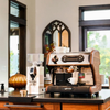 lucca a53 mini walnut espresso machine next to a white coffee grinder