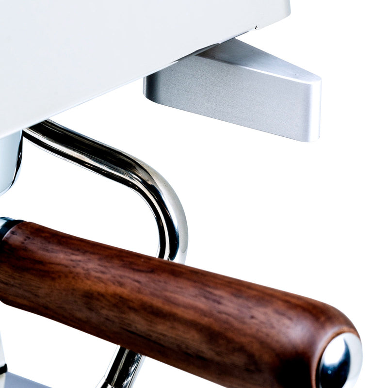 Close-up of a coffee grinder with wooden handle and metal body on a white background