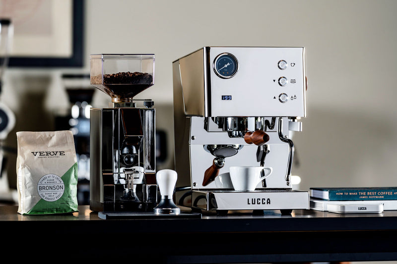 Espresso machine with coffee beans and a bag on a table