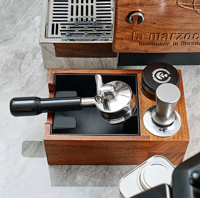 Wooden knockbox with metal components on a gray surface, featuring 'La Marzocco' branding.