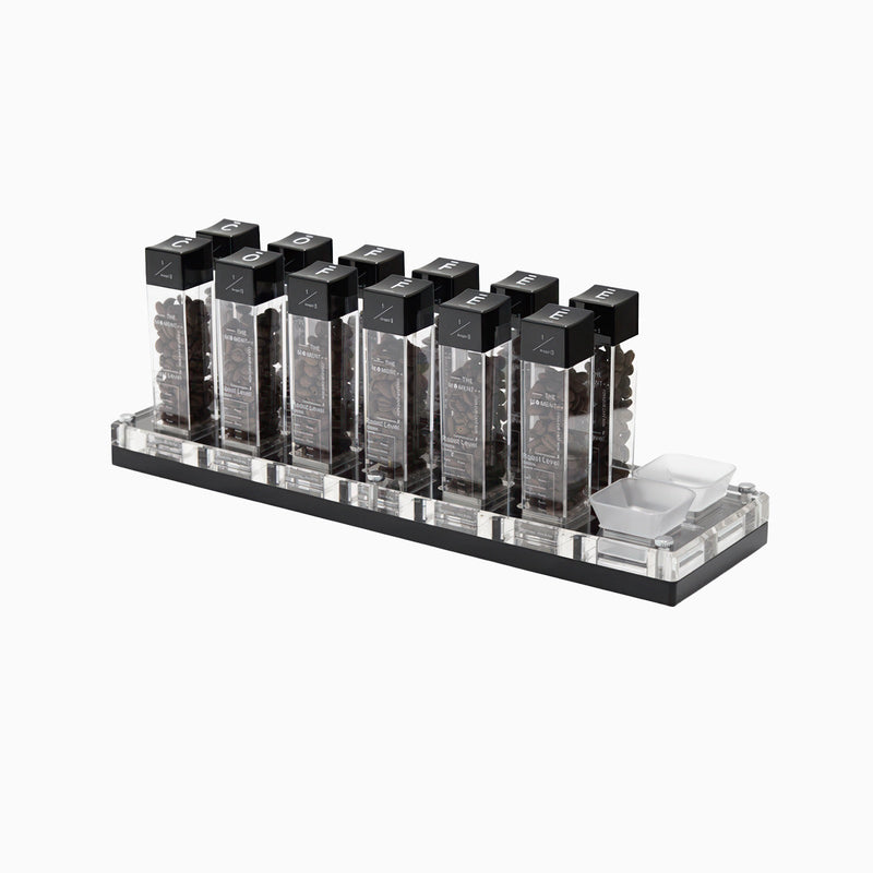 Set of black and clear lipsticks on a stand with a white background