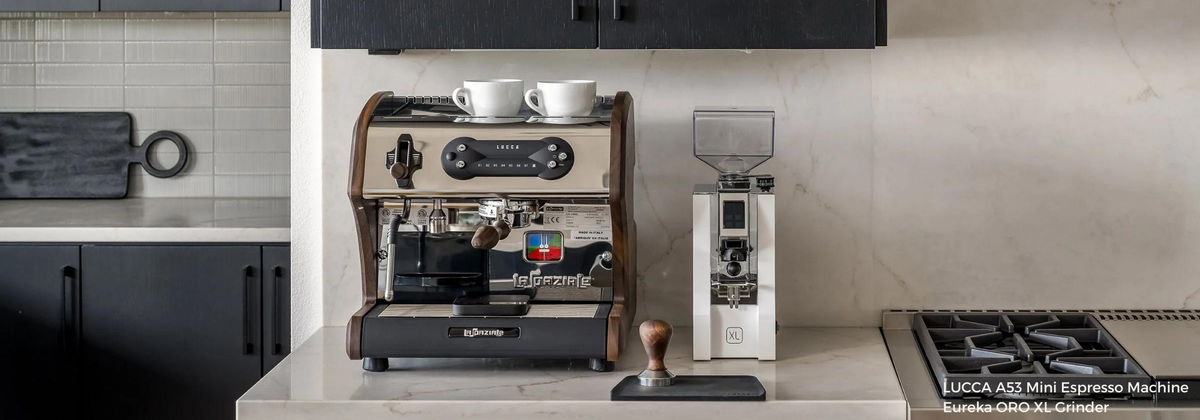 lucca a53 espresso machine next to a white coffee grinder